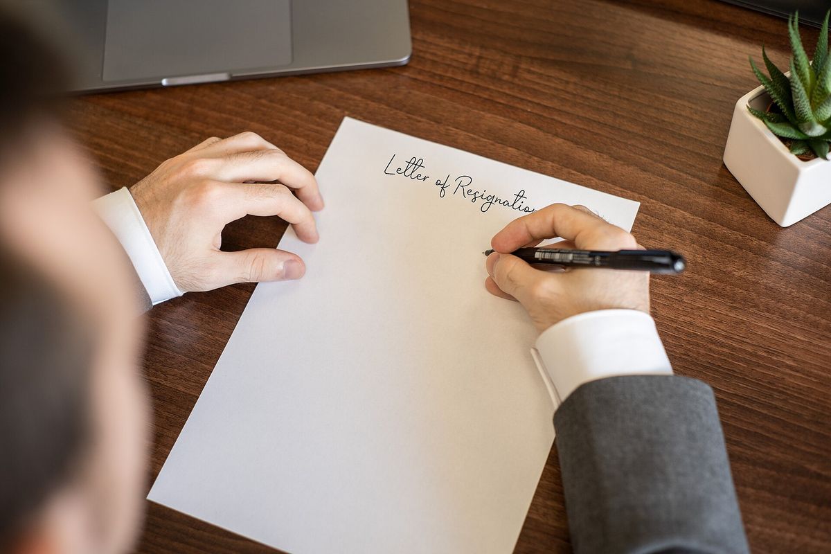 Photo of someone handwriting their letter of resignation while sitting at their office desk. This is licensed under the Attribution Creative Commons licence, which means that you c