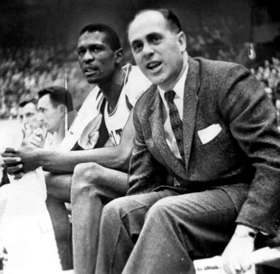 Boston Celtics center Bill Russell sitting on the bench next to head coach Red Auerbach.