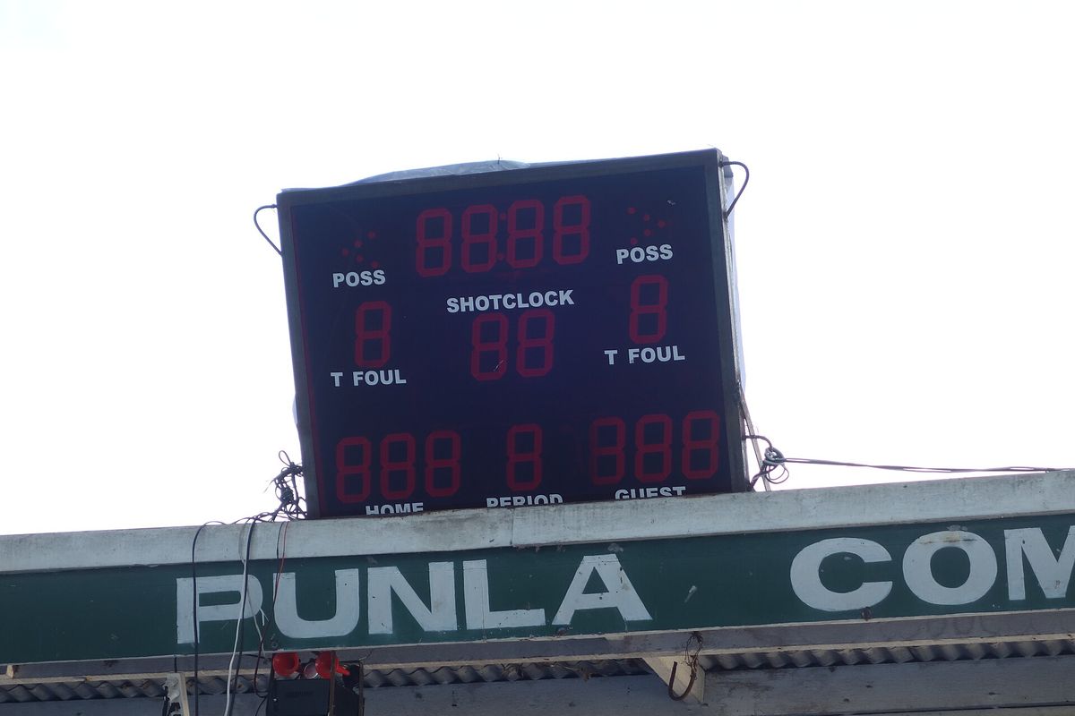 The electronic scoreboard for the sheltered basketball court above the adjacent community stage of Banga Municipal Park, commonly called "The Plaza", between Quezon Avenue and Roxa