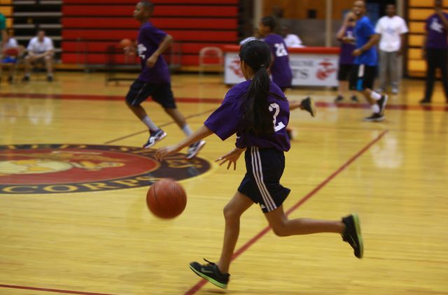 A student from Brewster Middle School dashes across the court during a Hoops-N-Dreams jamboree aboard Camp Lejeune, N.C., Feb. 22, 2013. Children of varying ages and skill levels p